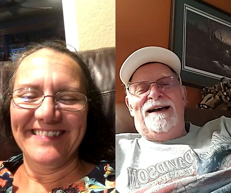 Two smiling adults sit side by side in a split-screen selfie: a woman on the left with glasses and colorful top, and a man on the right with a white cap and gray shirt.