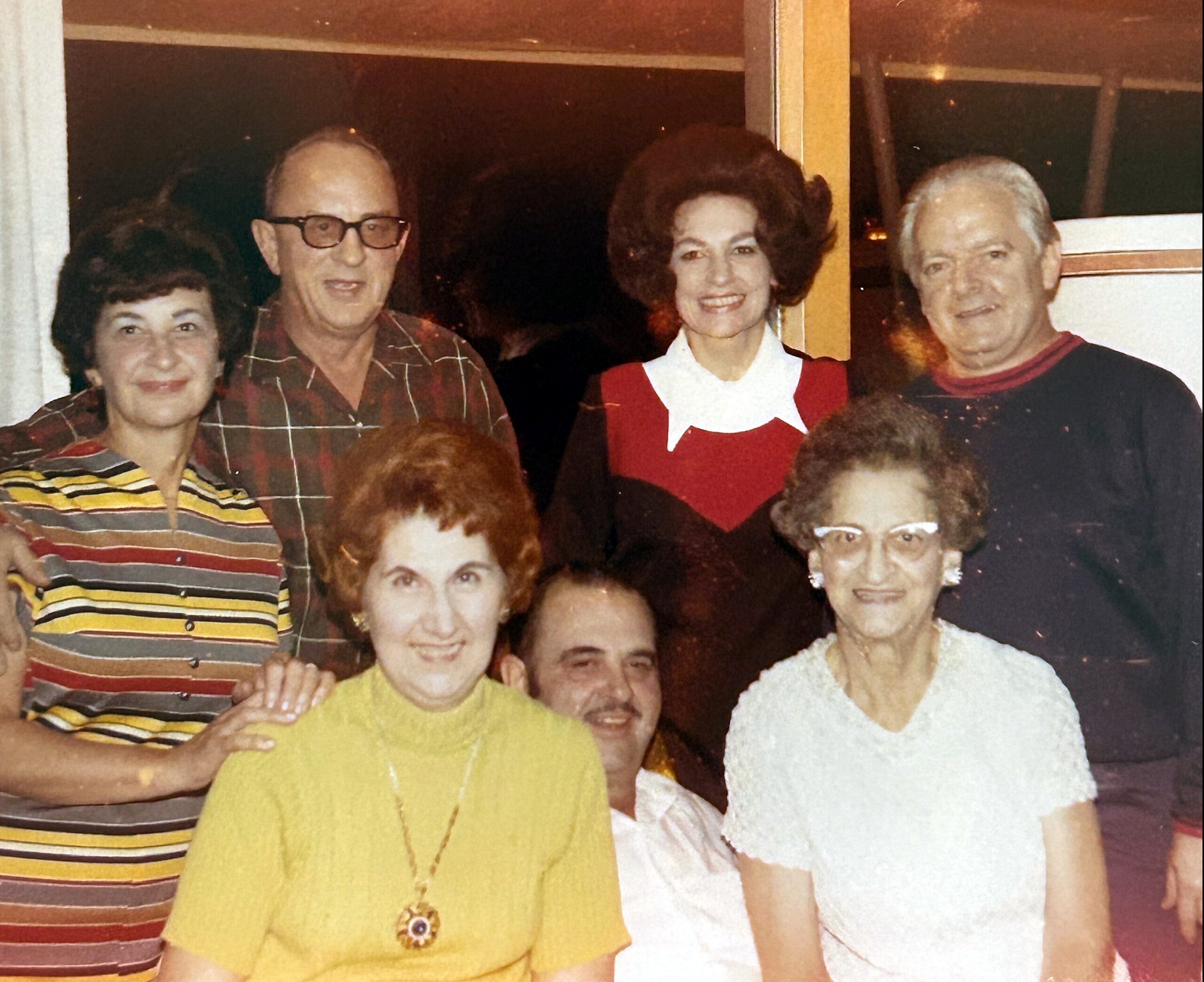 Group of smiling seniors posing together for a photo at a social gathering.