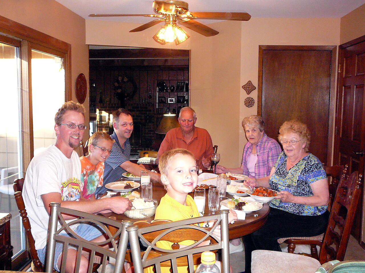 A family seated around a wooden dining table enjoying a home-cooked meal together.