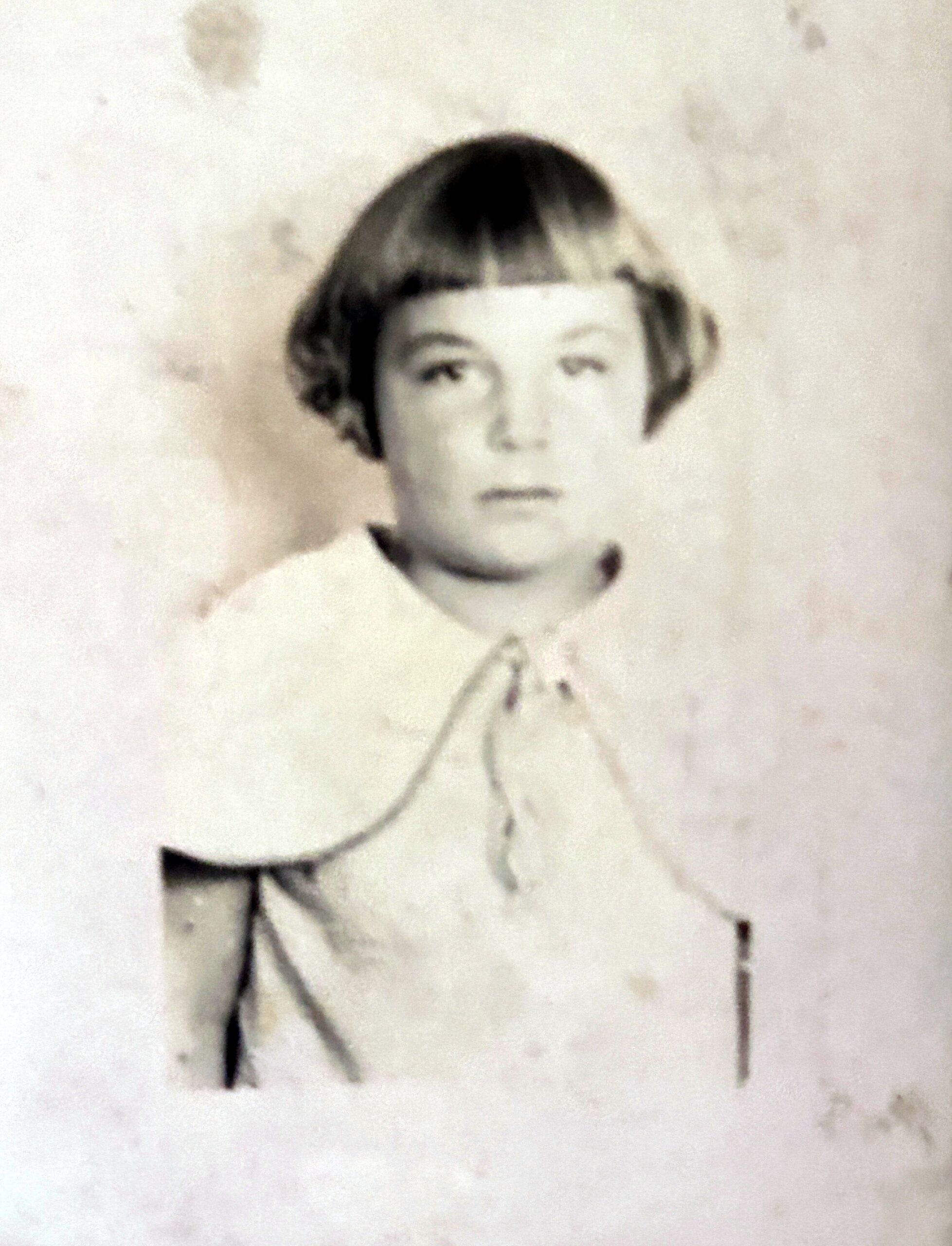 Black-and-white bust portrait of a young person with short dark hair, facing the camera against a plain background.