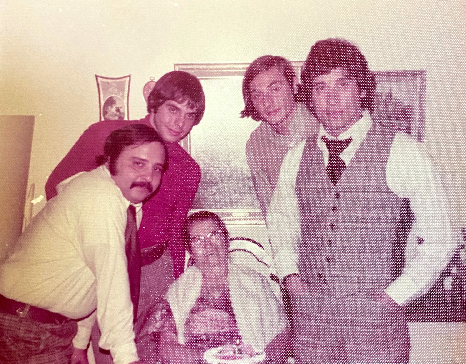 Group of five people posing for a vintage indoor photo, wearing 1970s-era clothing.