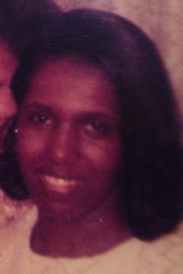 Head-and-shoulders portrait of a smiling woman with dark hair, looking at the camera.