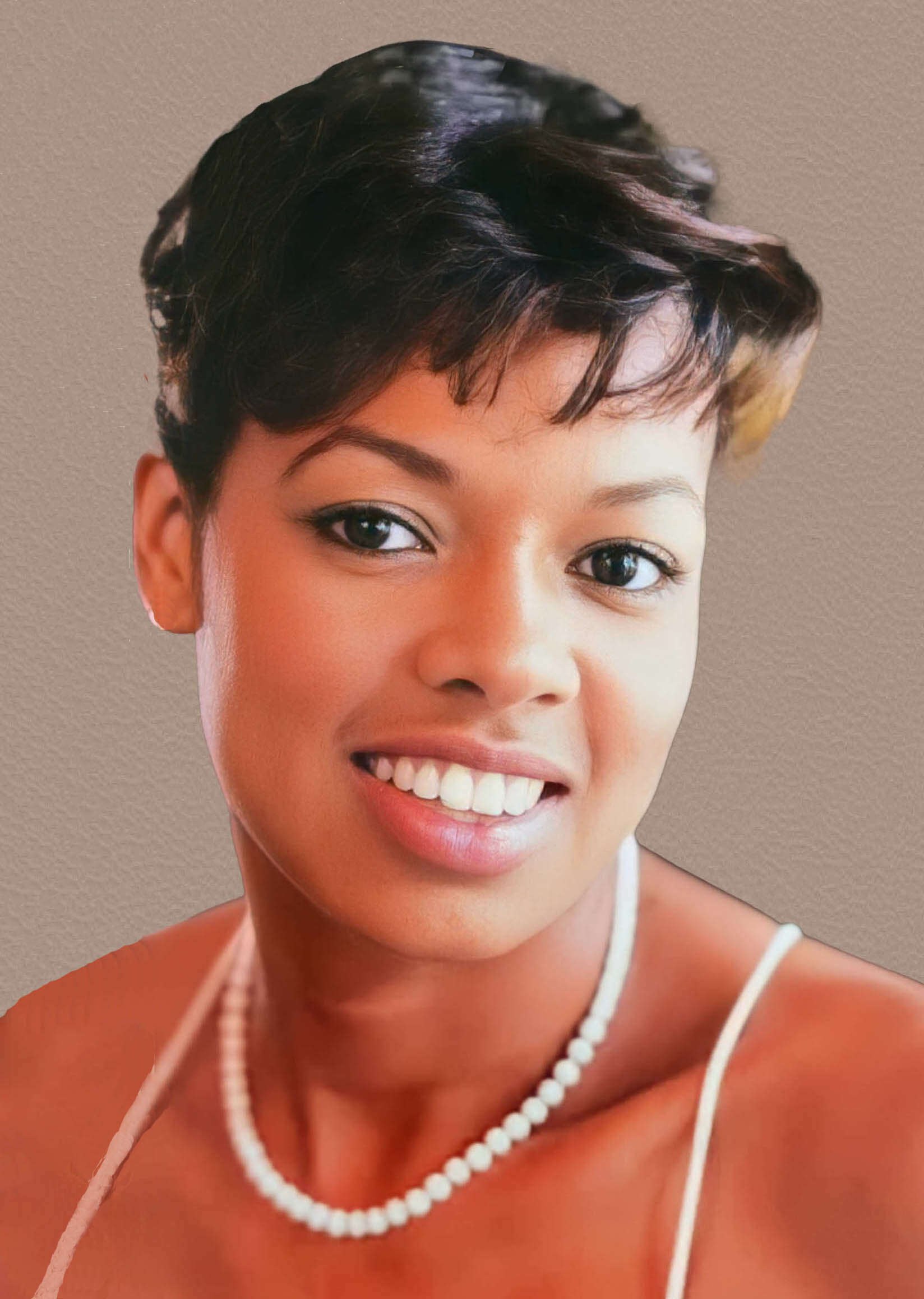 Close-up portrait of a smiling woman with short black hair, wearing a pearl necklace against a beige background.