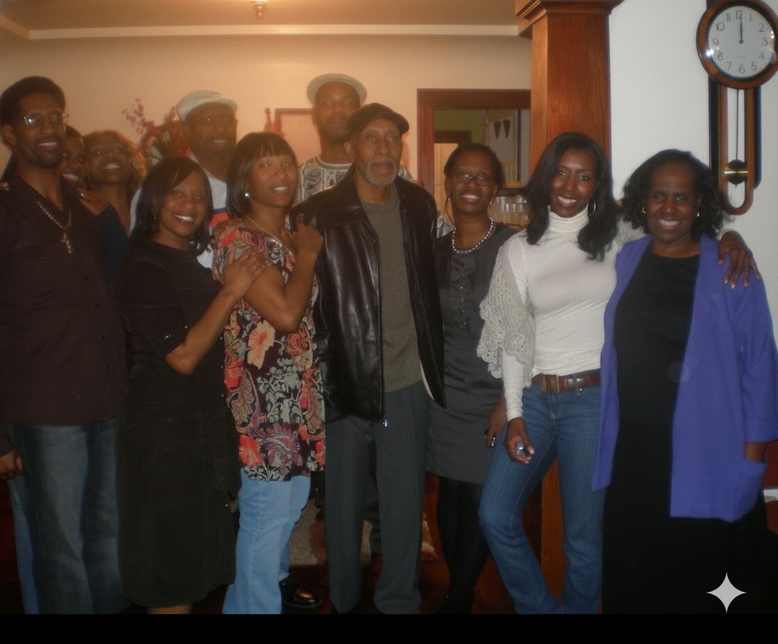 Group of adults posing together in a living room, smiling for the photo at a casual gathering.