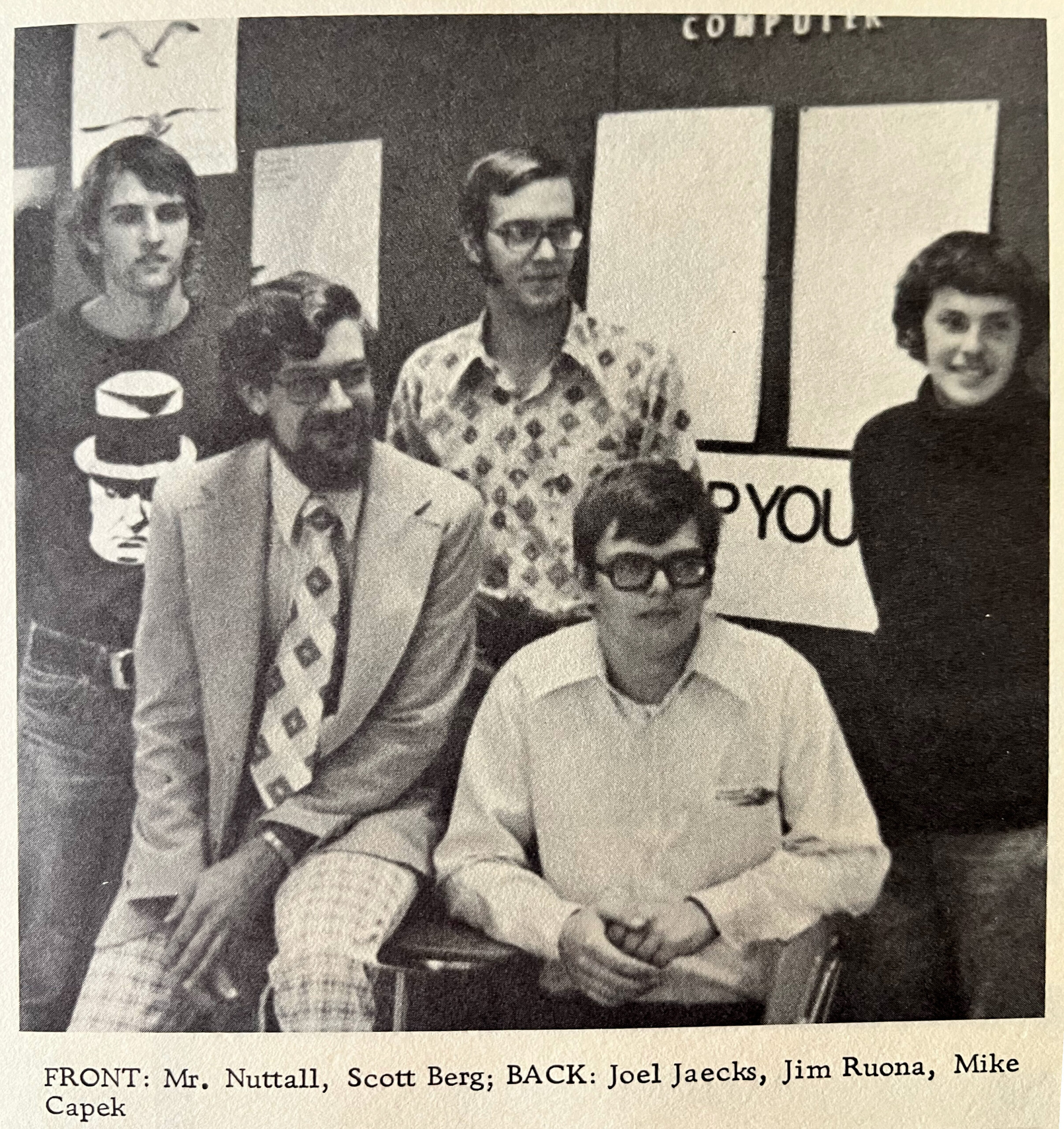 Black-and-white group photo: several men, one seated in front, others standing behind; caption shows FRONT and BACK names.