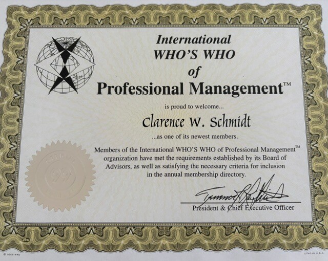 Certificate from International Who's Who of Professional Management welcoming Clarence W. Schmidt as a new member, with gold seal and ornate border.