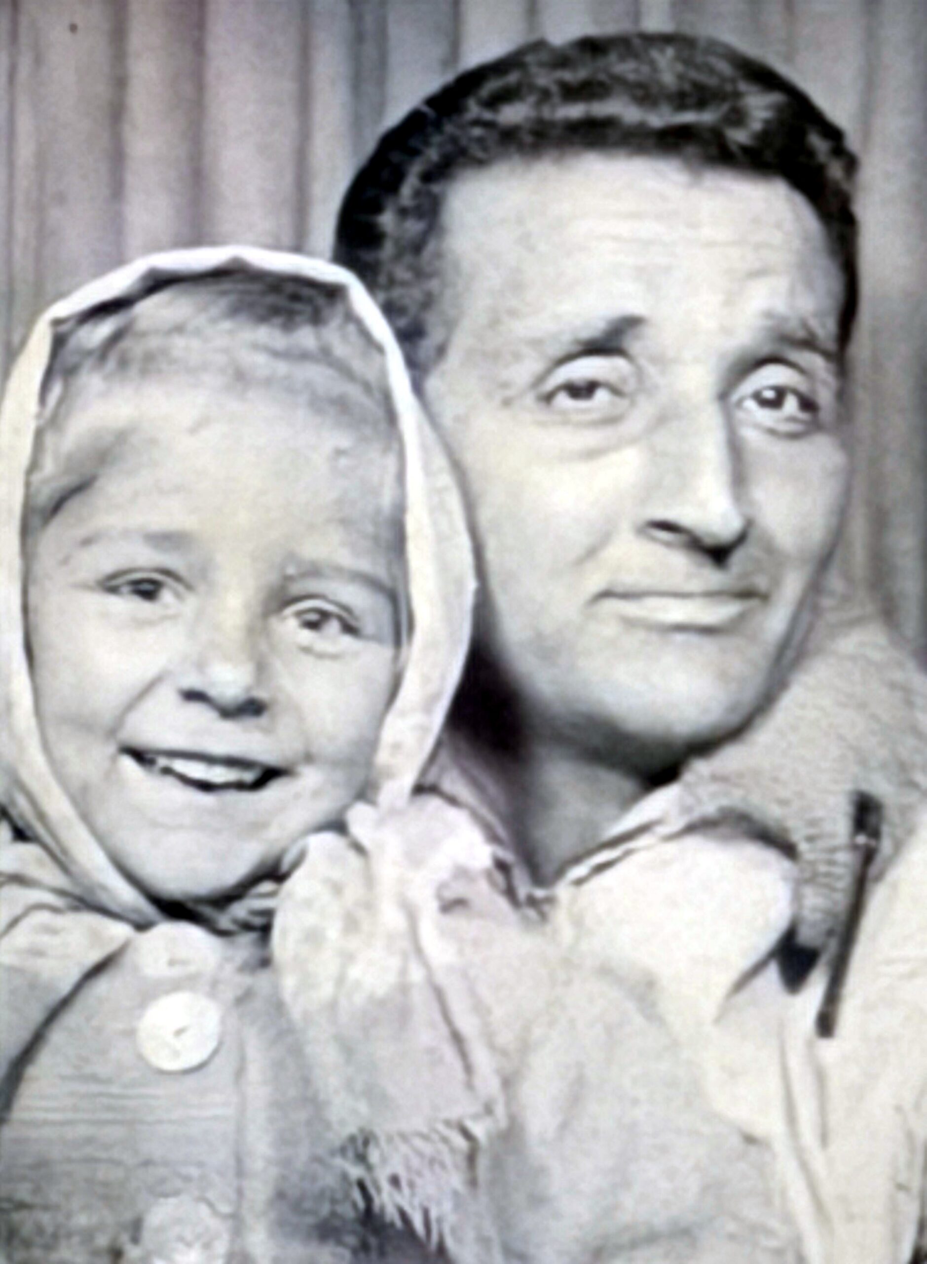 Close-up of a smiling woman and child in coats posing for a photo.