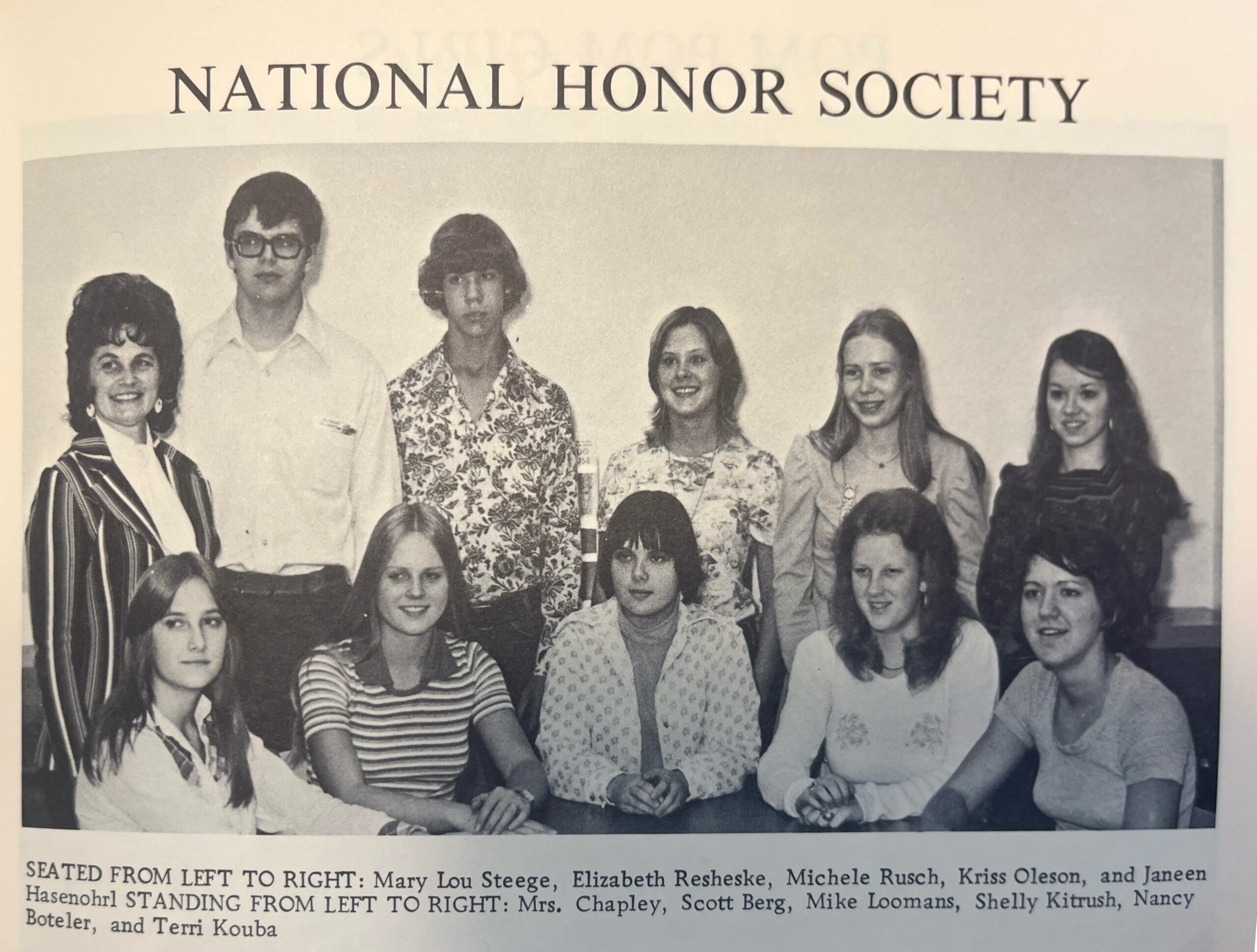Group yearbook photo of students seated and standing, with a caption naming individuals from left to right.