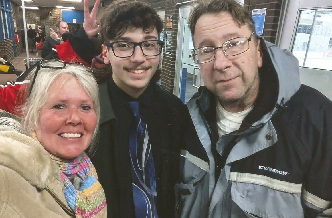 Group selfie at a station: smiling woman in a scarf, young man with glasses and a tie, and a man in a gray IceArmor jacket on the right.