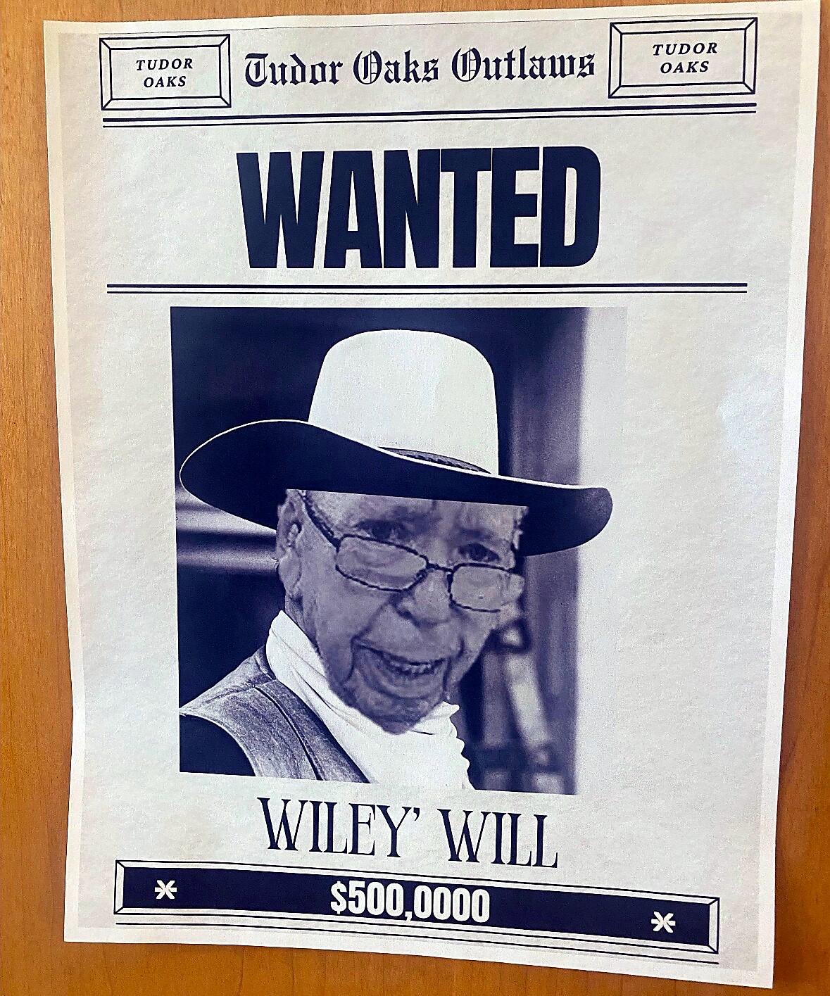 Wanted poster featuring an elderly man in a wide-brim hat and glasses, labeled Wiley Will, with a $500,000 reward.