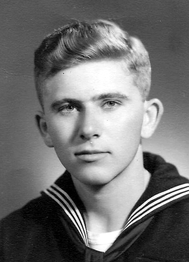 Black-and-white portrait of a young man wearing a navy sailor uniform with striped collar, looking slightly to the left.