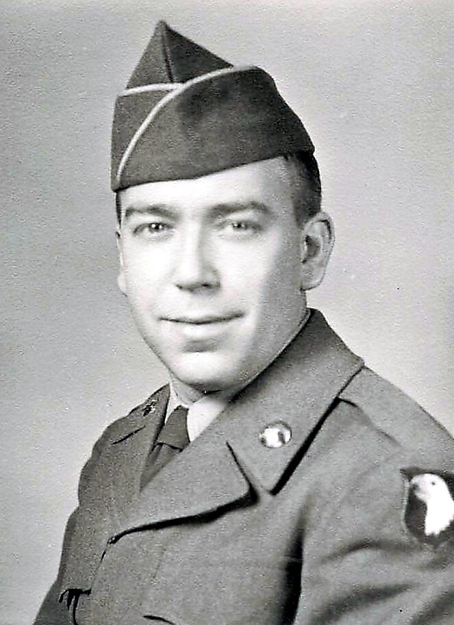Portrait of a young man in a vintage military uniform wearing a peaked cap, in black-and-white.