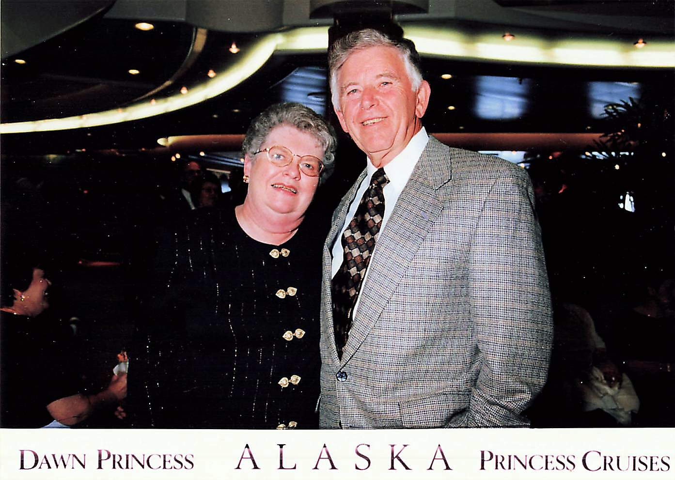 Couple posing together at a Dawn Princess Alaska cruise event, smiling at the camera.