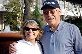 Smiling older couple posing outdoors with arms around each other.