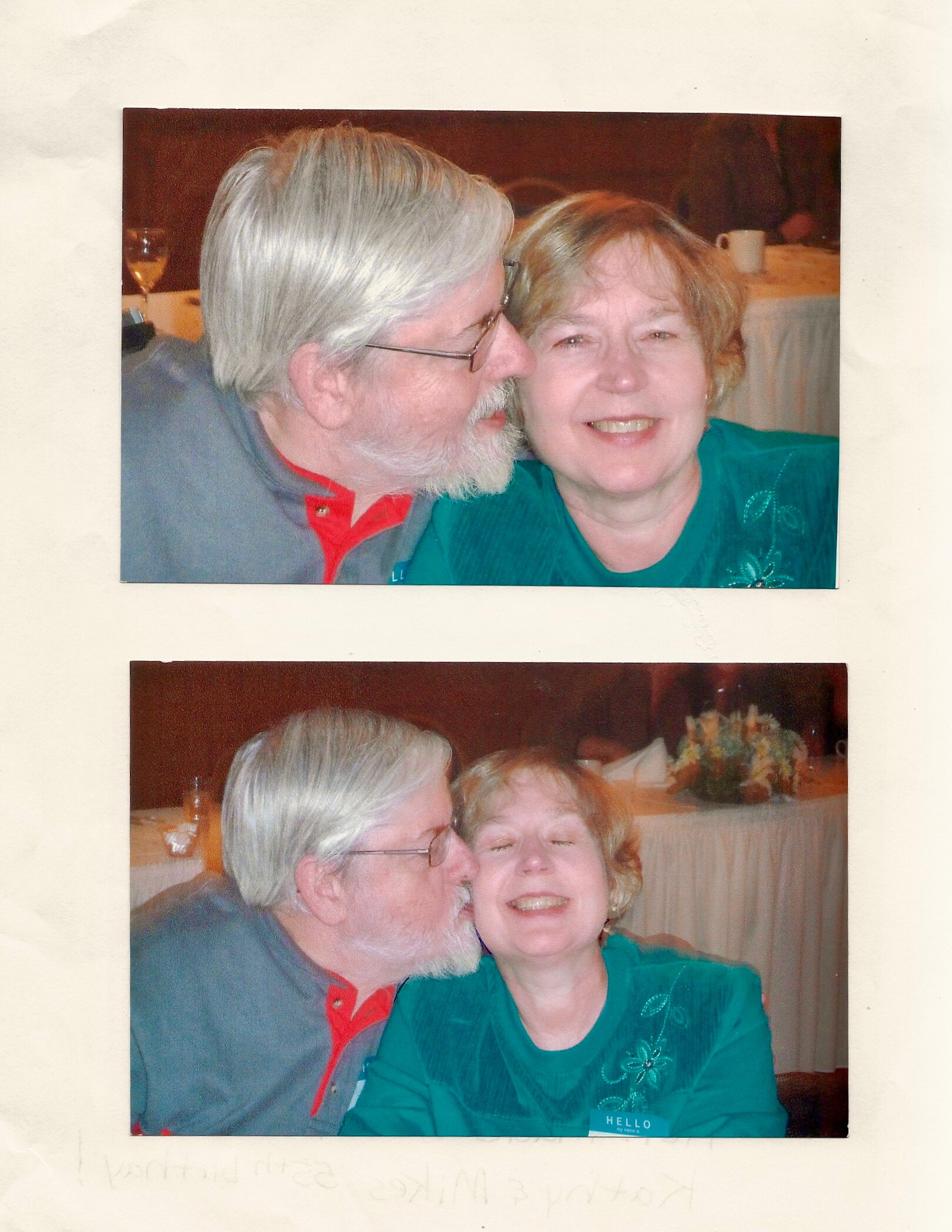 An older man with white hair and beard leans in to kiss a smiling woman wearing a teal top at a social gathering.