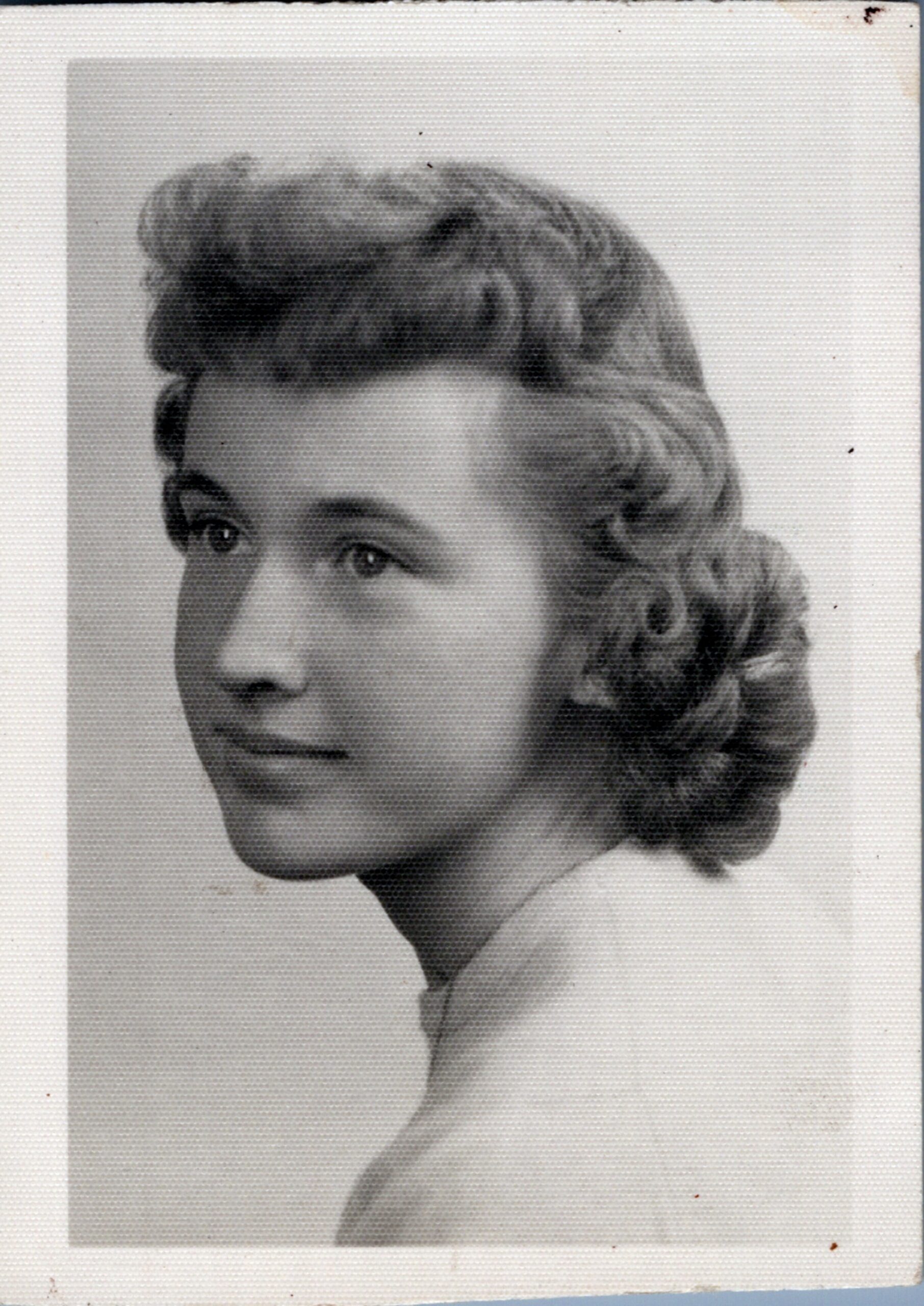 Portrait of a young woman in a vintage updo, looking to the left.