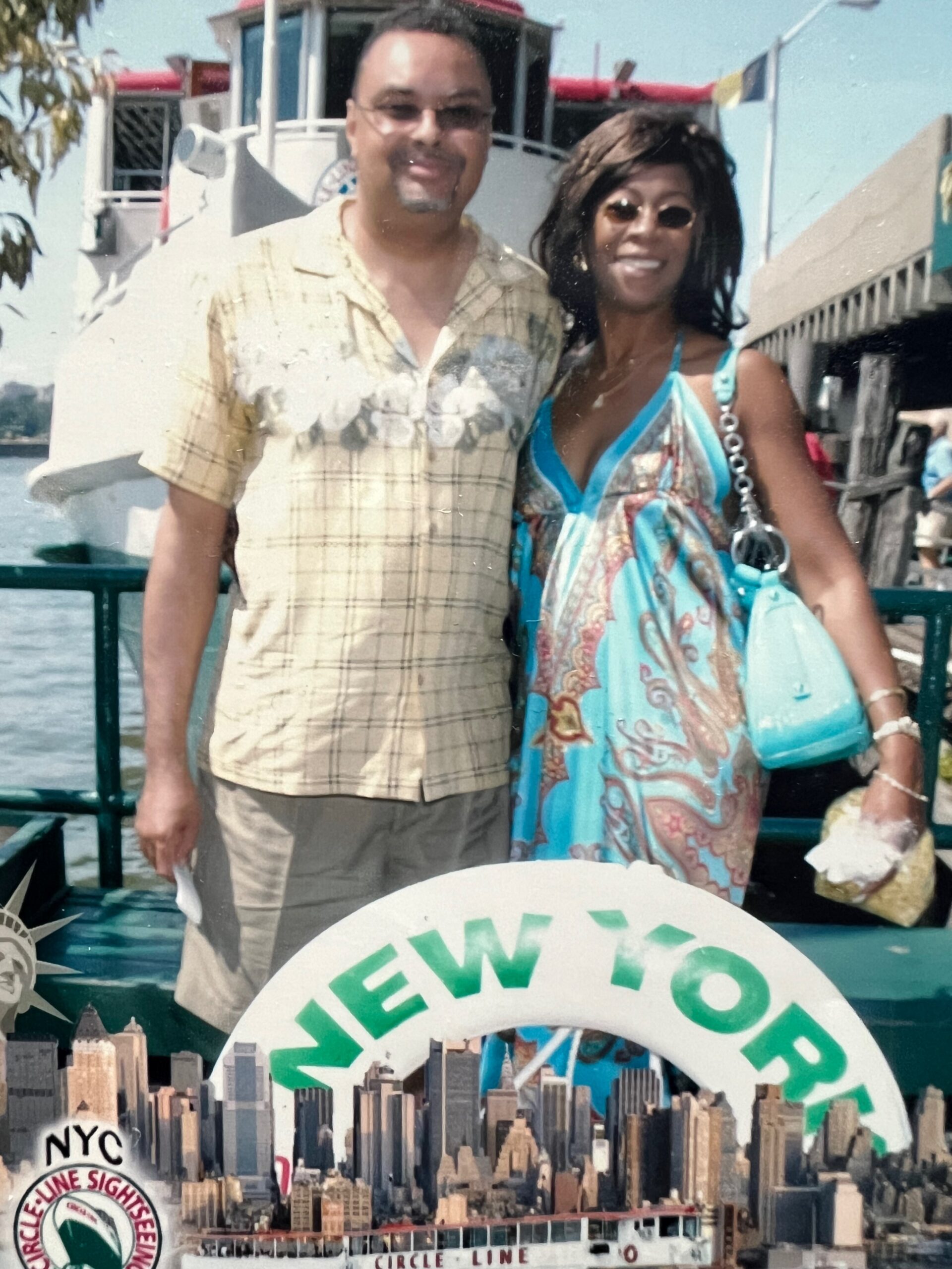 Smiling man and woman pose together on a boat by the water during daytime vacation.