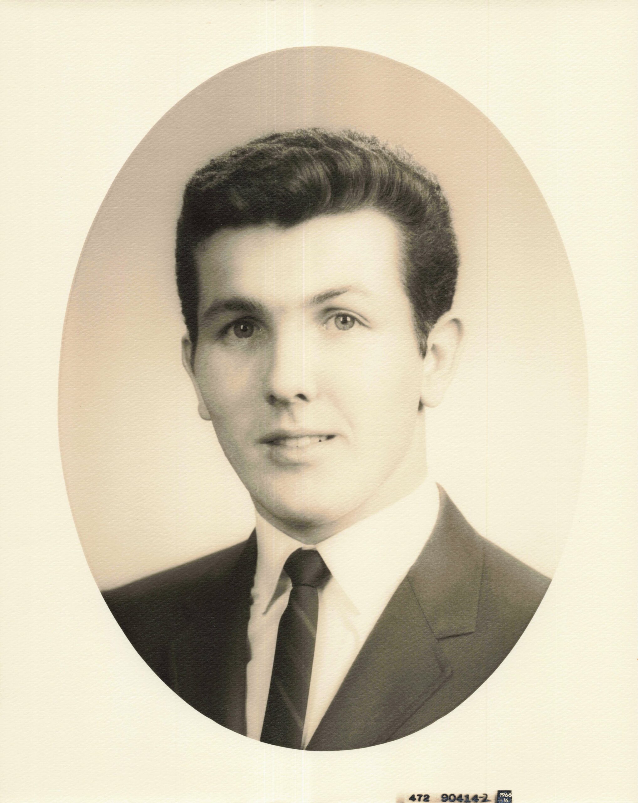 Formal vintage portrait of a man in a suit with a tie, set against an oval backdrop.