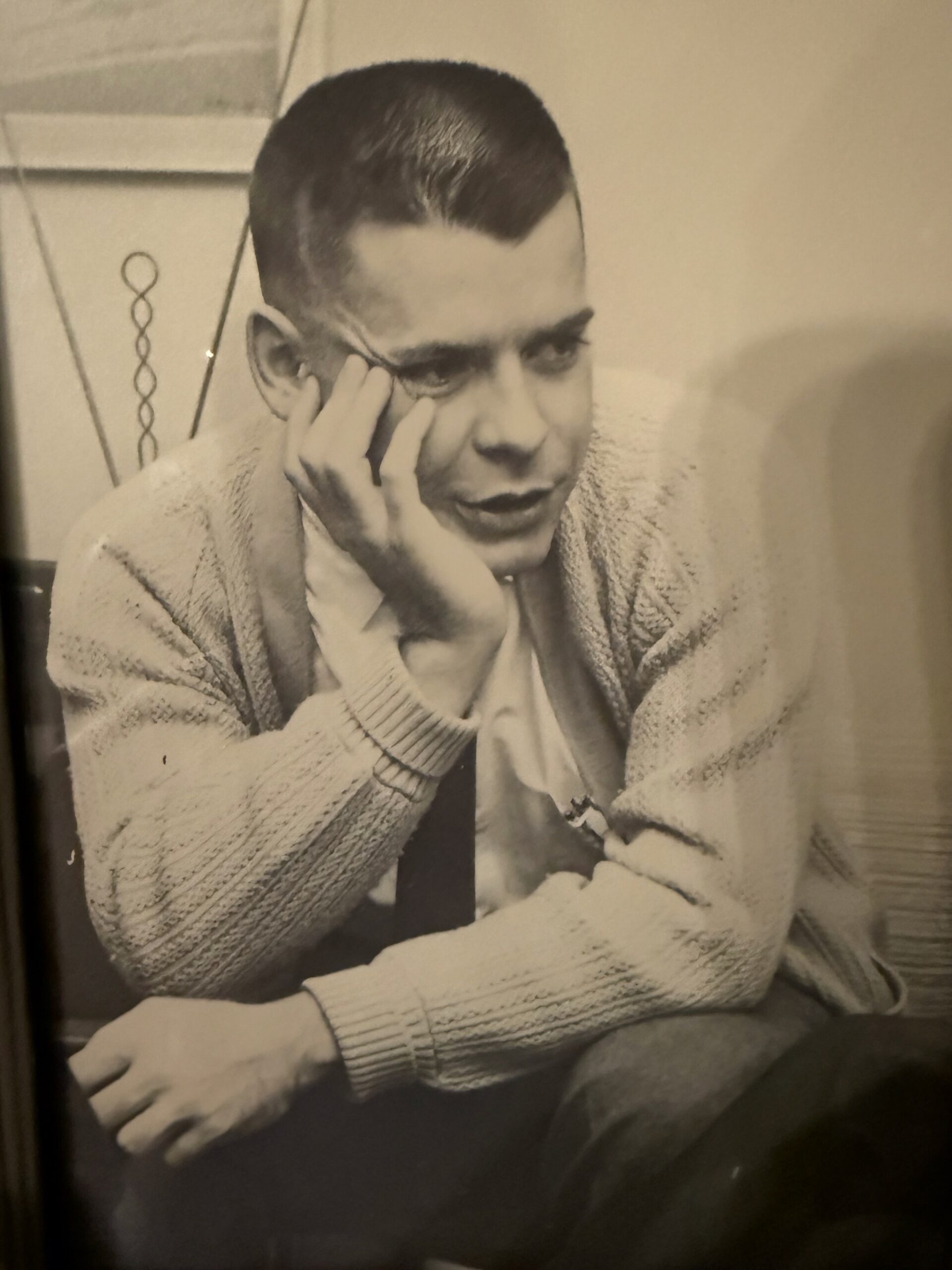 Black-and-white photo of a man resting his chin on his hand, looking thoughtful at the camera's side.