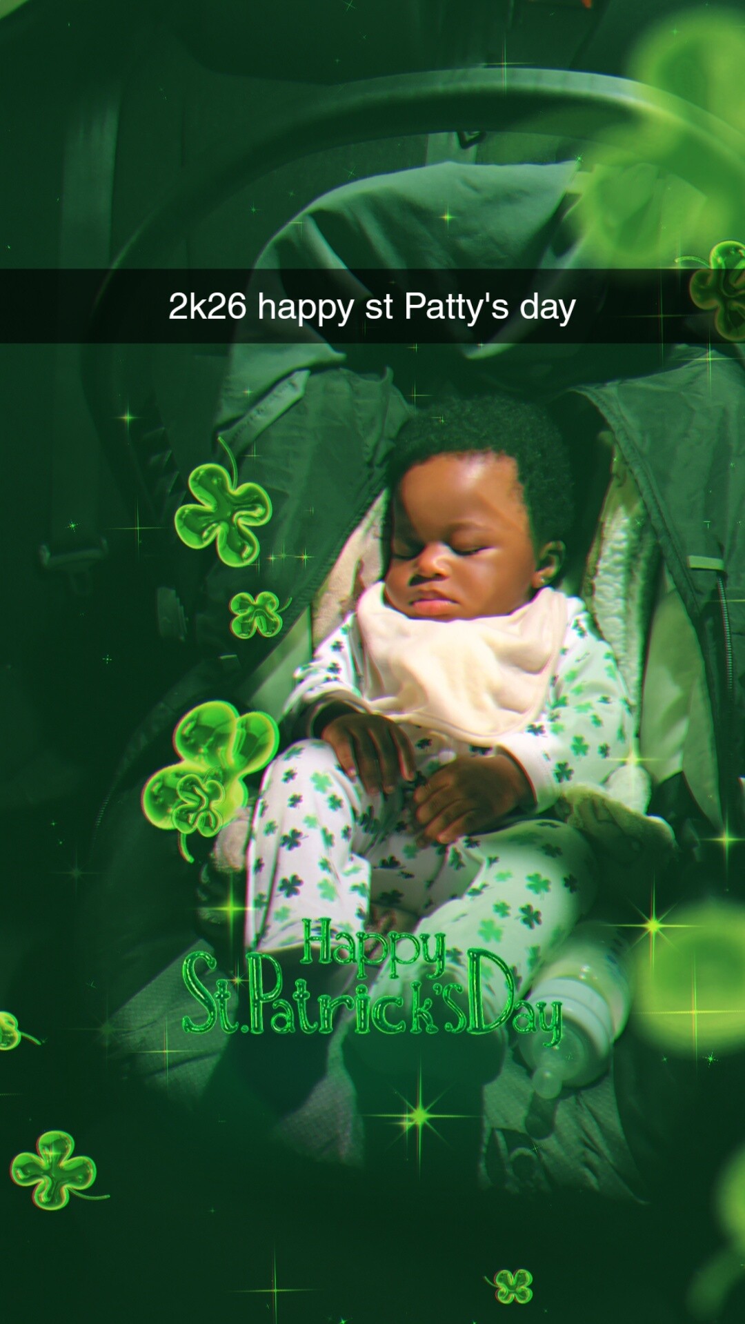 Sleeping baby in a stroller, surrounded by glowing green shamrocks for St. Patrick's Day.