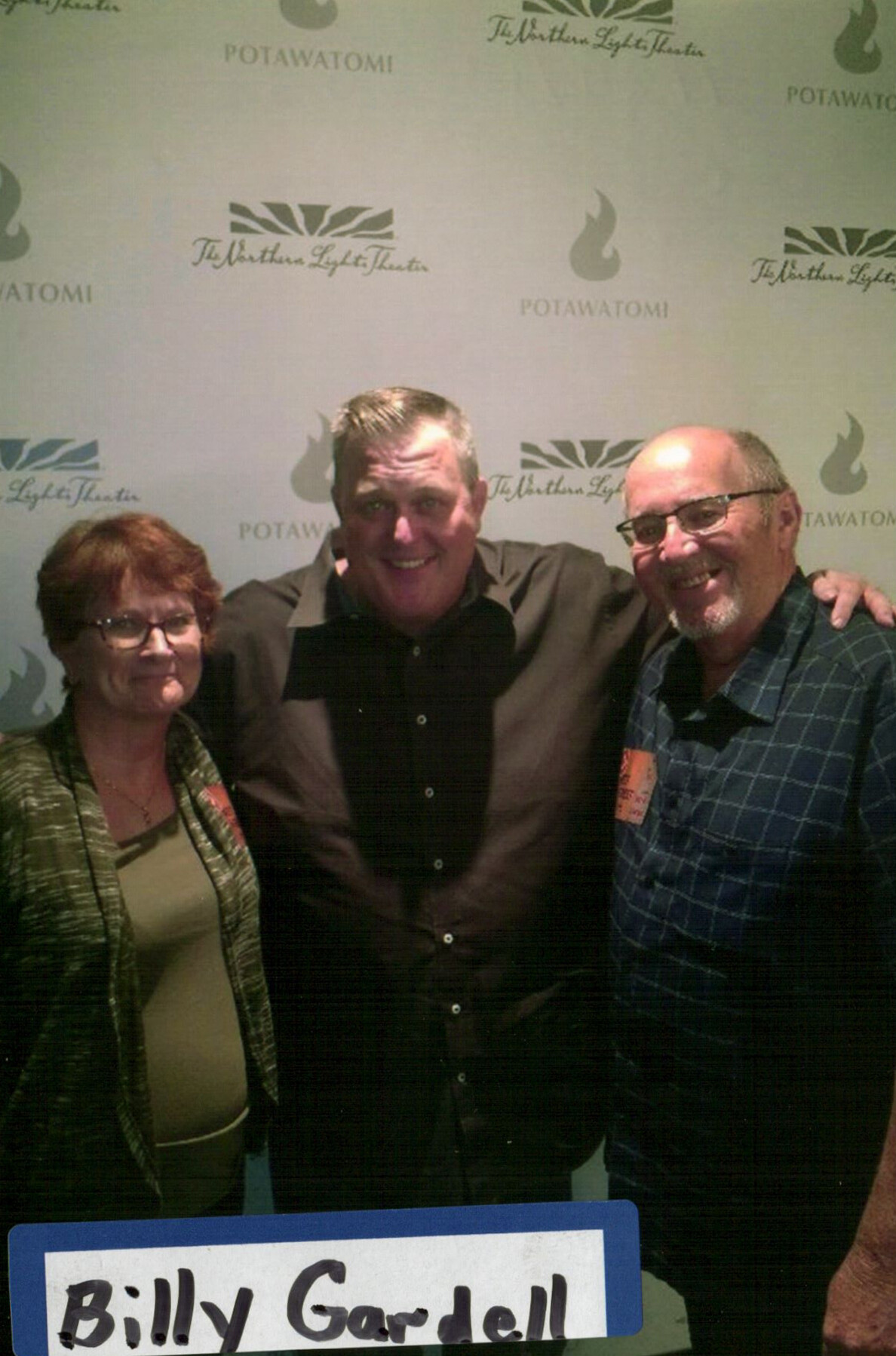 Three people pose together in front of a step-and-repeat backdrop with Potawatomi logos; bottom shows 'Billy Gardell' sign.