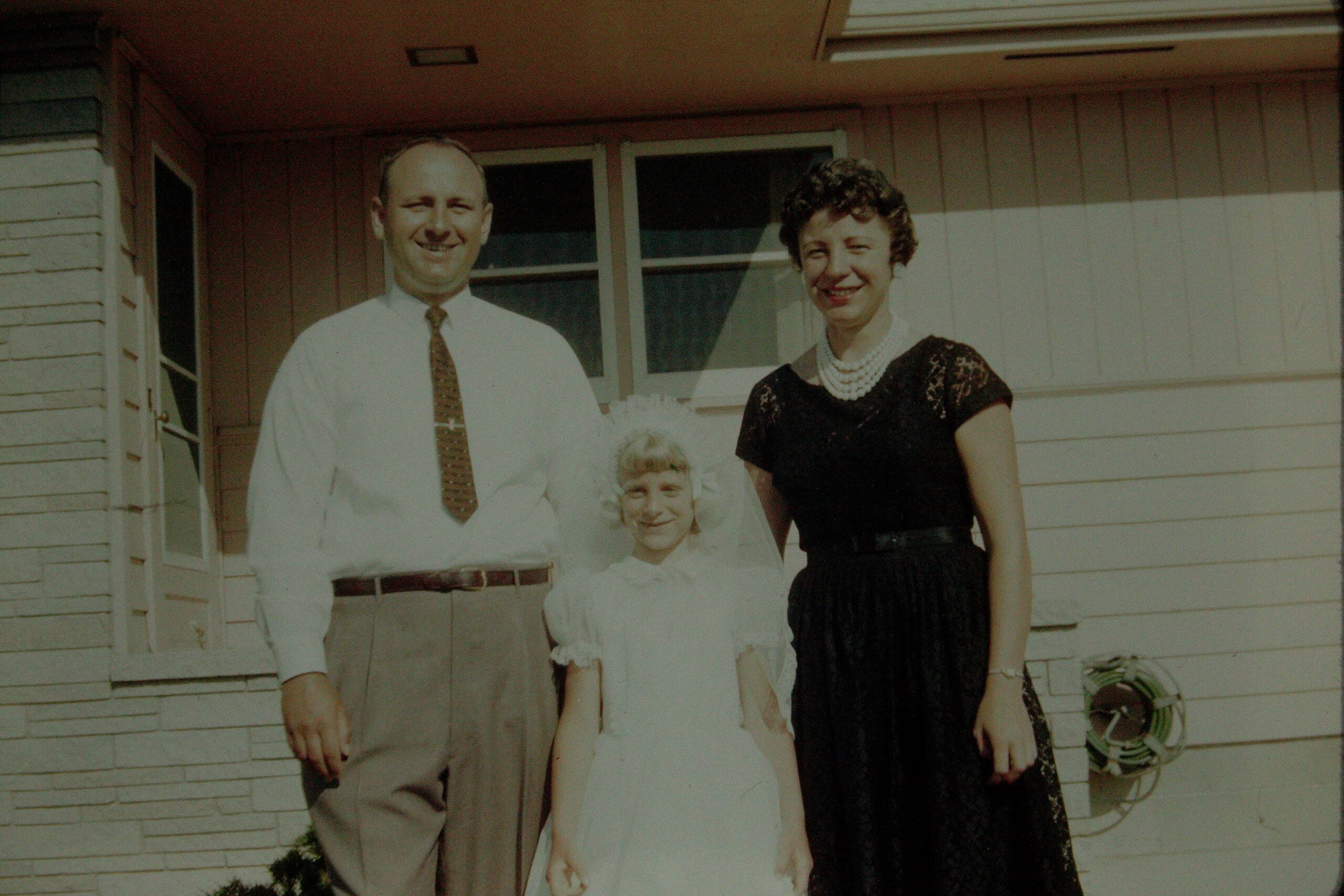 Life-size cardboard cutouts of a family posing on a house porch.