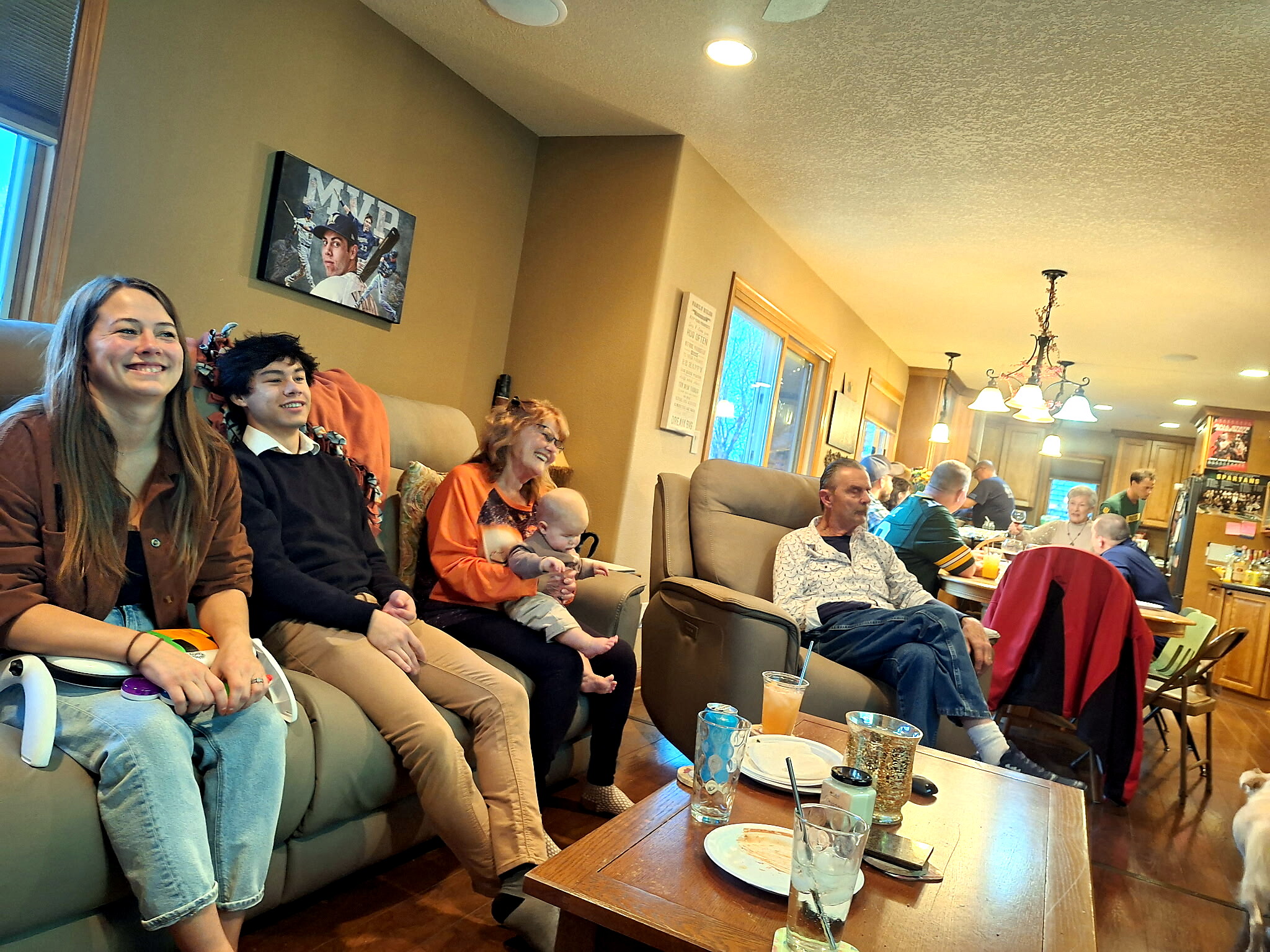 Group of people sitting on a beige couch in a living room, smiling and chatting during a casual gathering, with drinks on a coffee table in front.”]} }? Wait format must be array of strings. Let's provide multiple. Let's correct. 1-5.