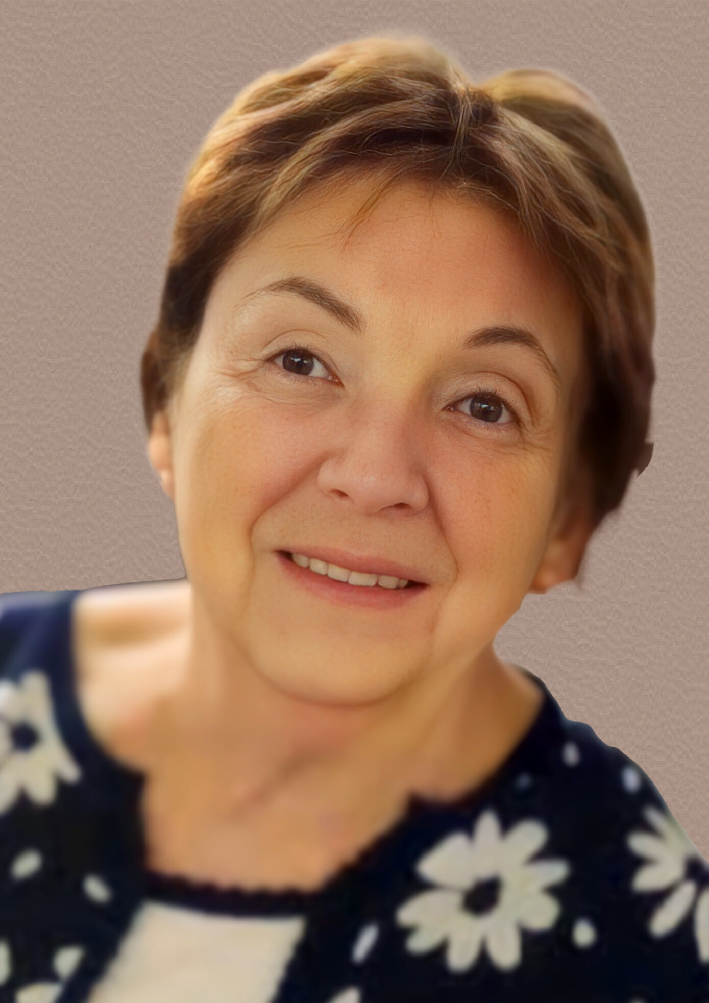 Close-up of a smiling woman with short light brown hair against a neutral textured background.