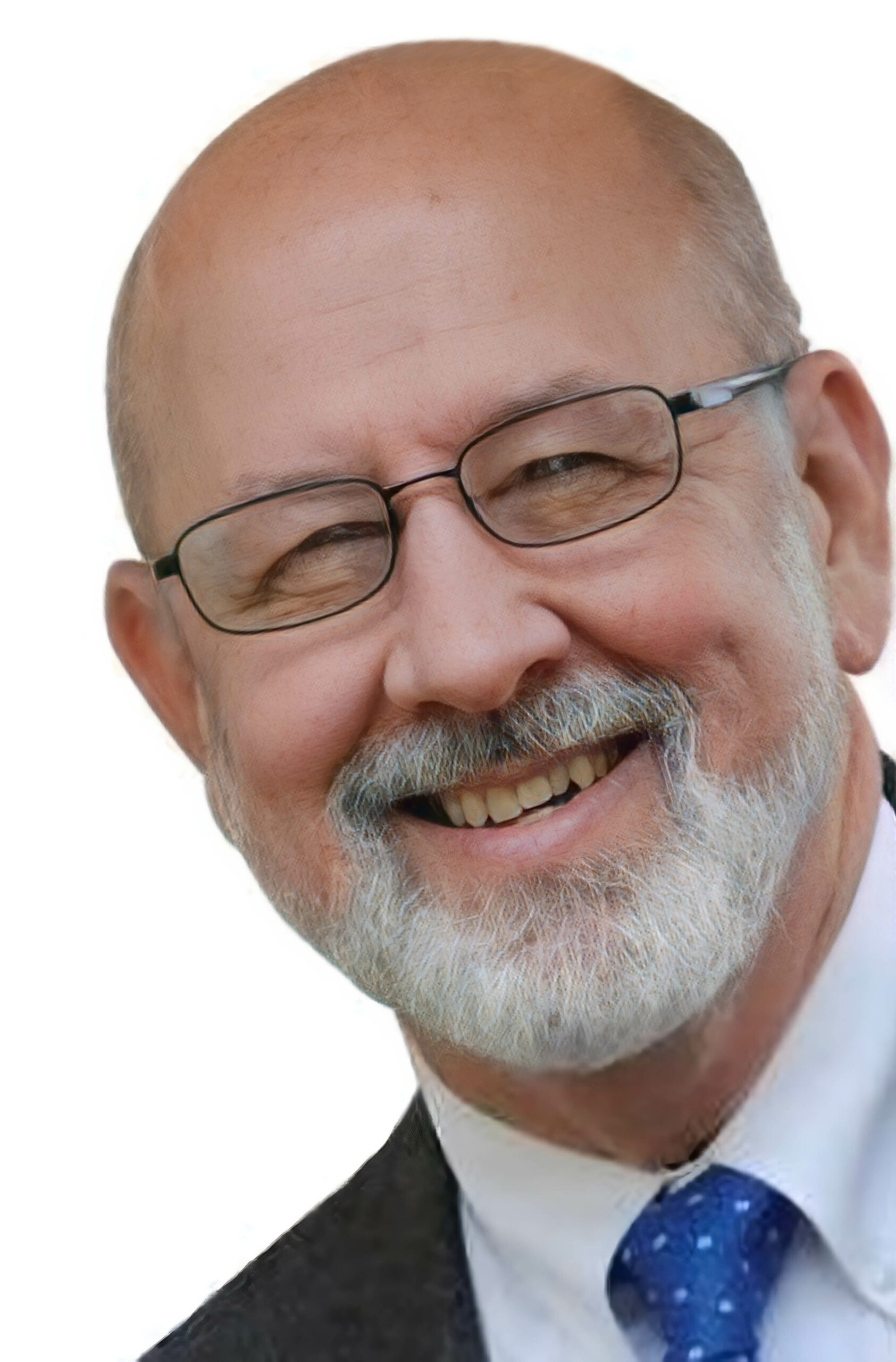 Smiling older man with glasses in a suit and blue tie, close-up portrait against a white background.