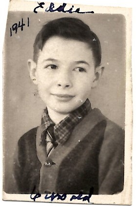 Black-and-white portrait of a young boy with short dark hair, wearing a plaid shirt and cardigan, looking to the side; handwritten '1941' along the left edge.