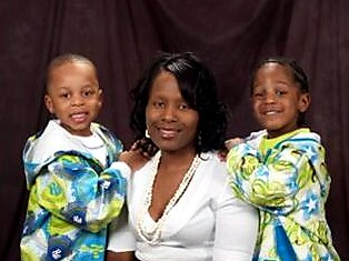 Mother with two children in matching colorful jackets posing for a studio portrait.