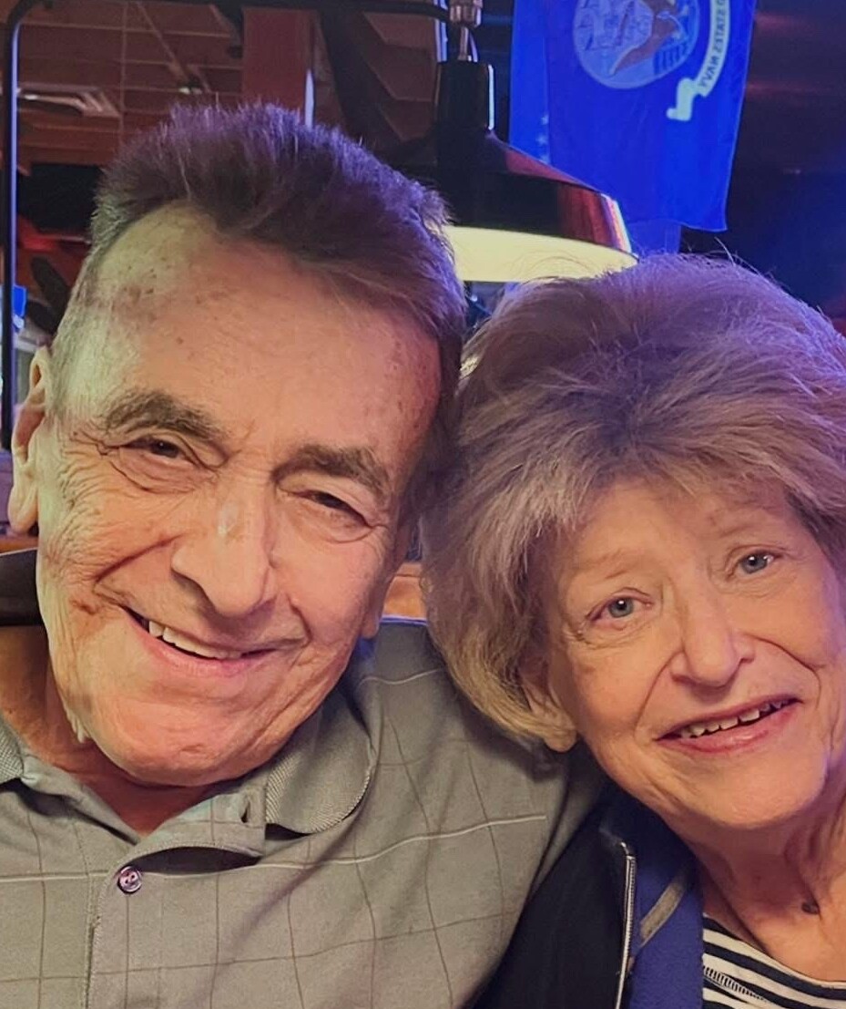 Senior man and woman smiling at the camera in a cozy dining setting