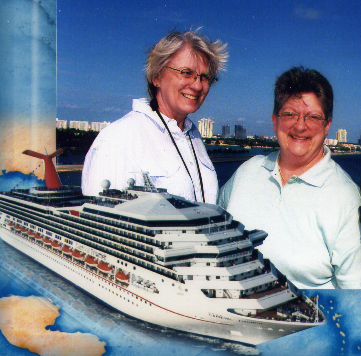 Two smiling women posing with a large model cruise ship against a blue sky backdrop.