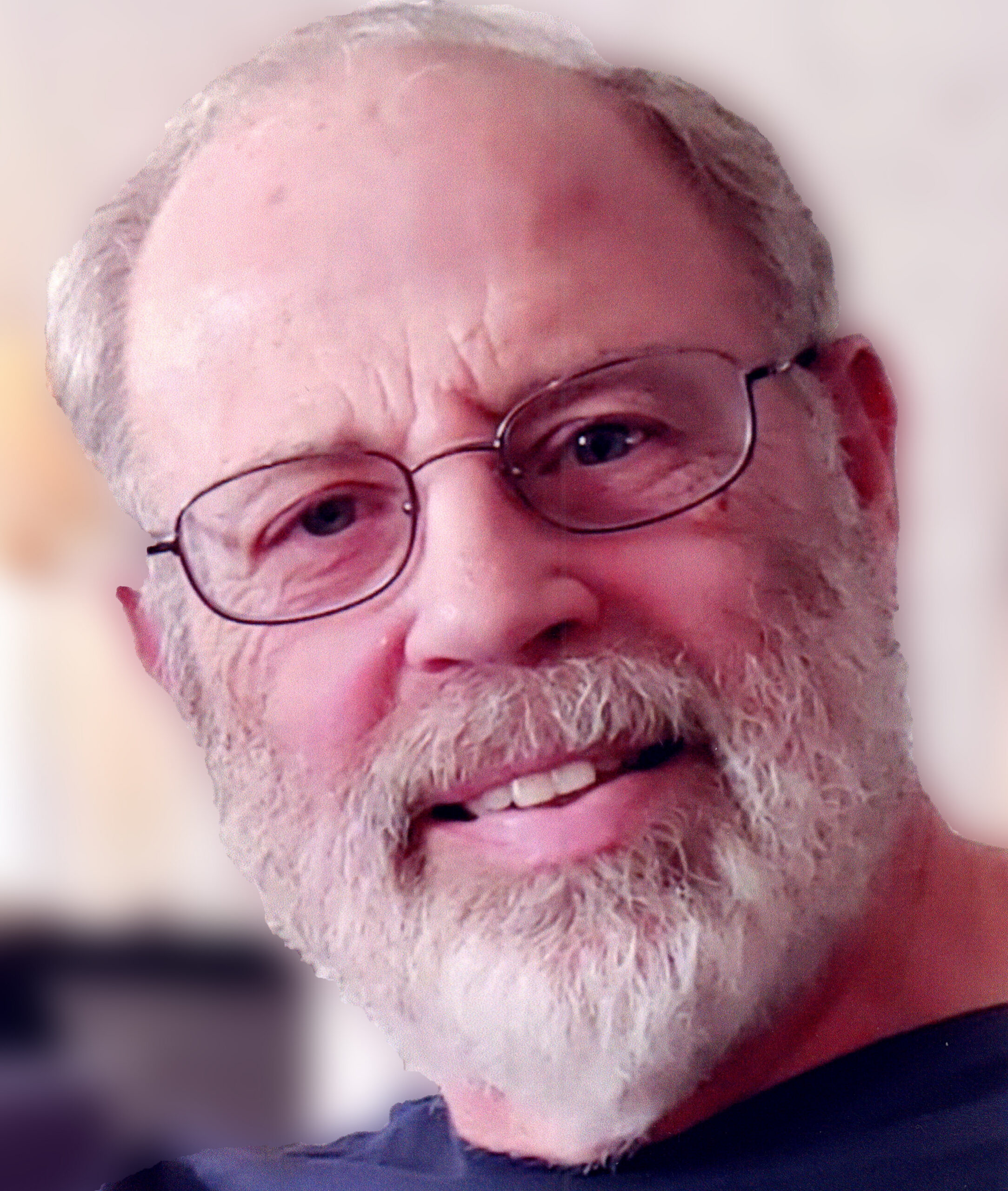 Close-up portrait of an elderly man with white beard and round glasses, smiling at the camera.