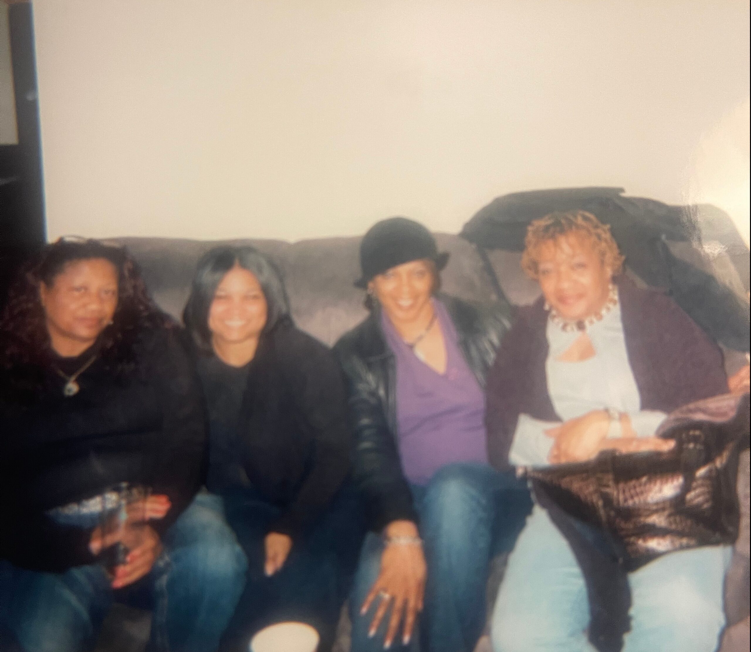 Group of people posing together for a photo, standing in a row indoors, smiling at the camera (party or casual gathering).