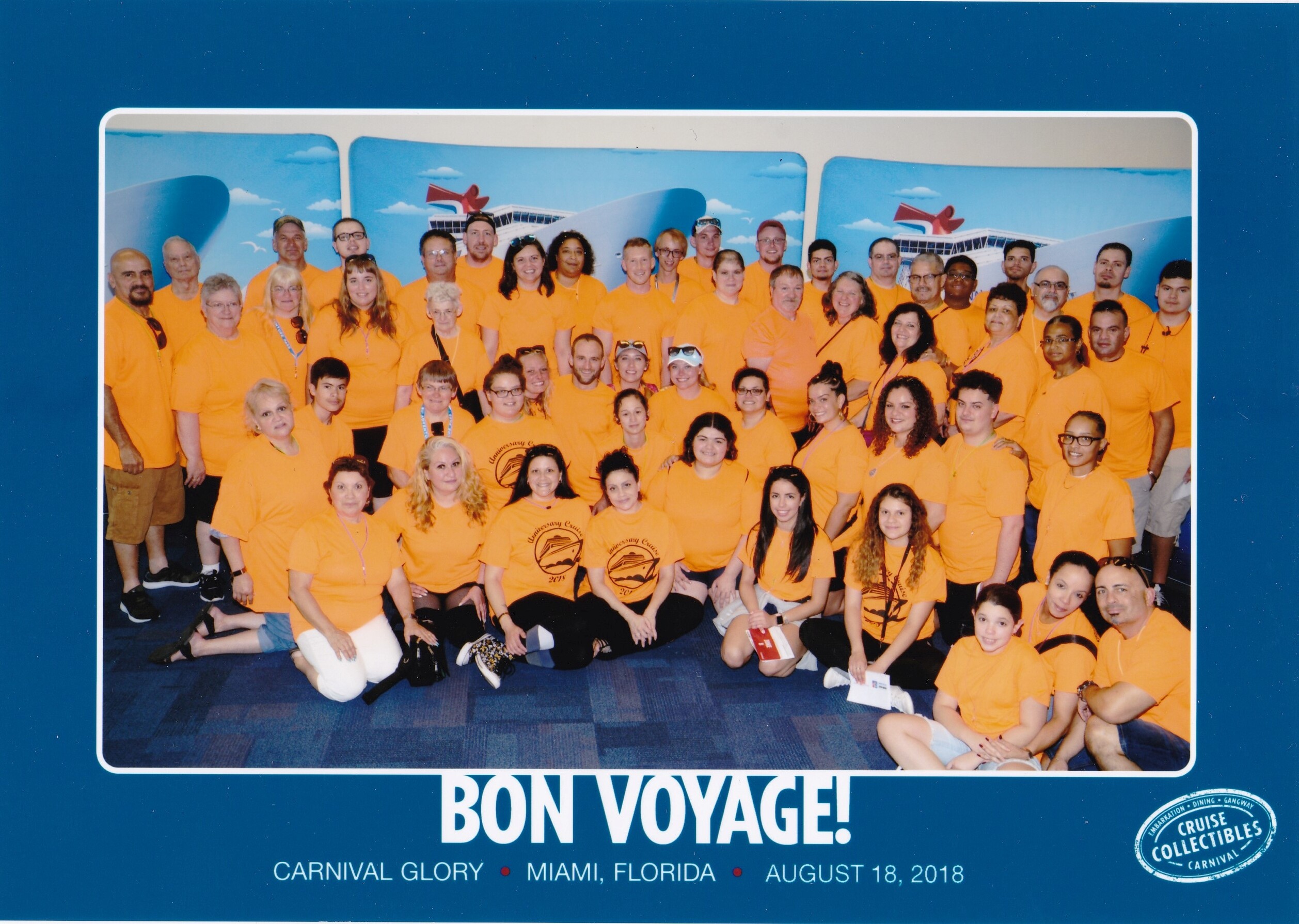 Large group of people wearing orange shirts posing together for a group photo at a cruise ship event, Bon Voyage.