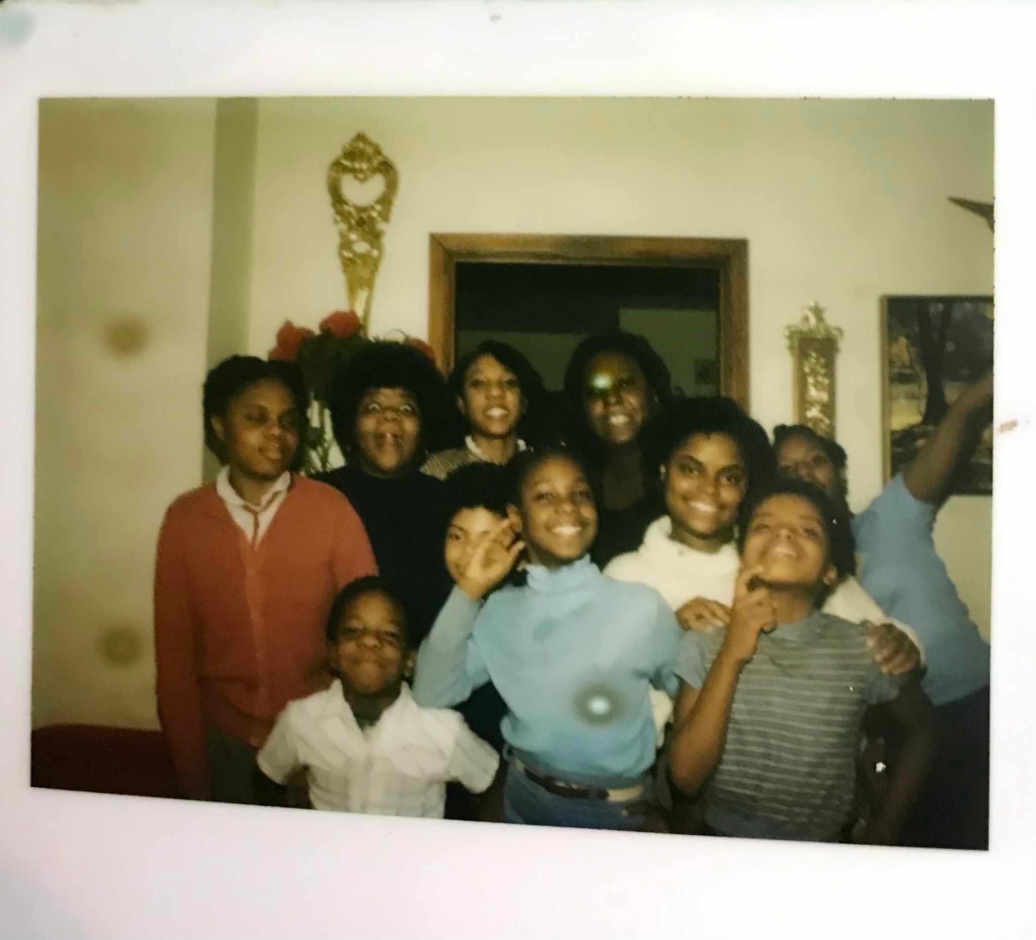 A group of people smiling and posing closely for a photo in a living room setting.