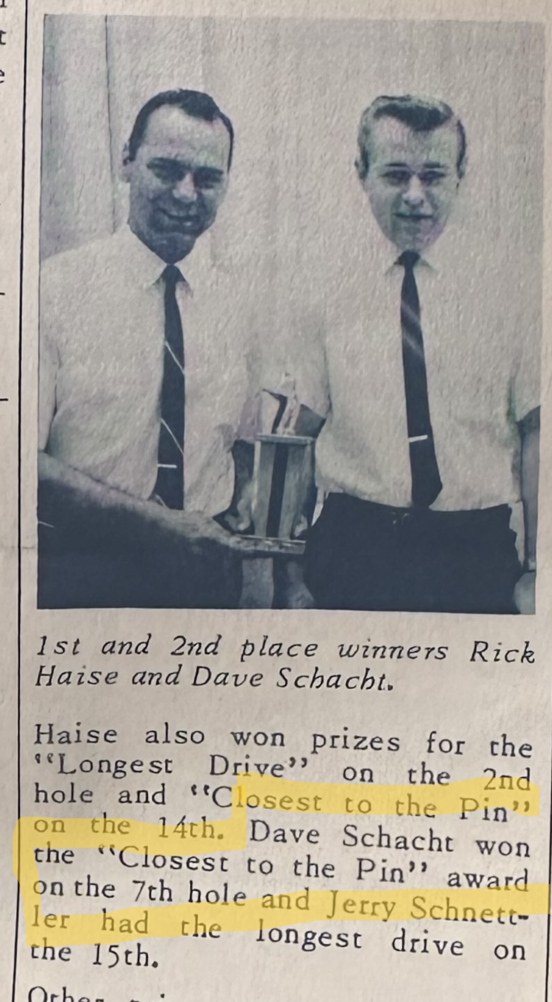 Two men in dress shirts and ties hold a trophy; caption reads '1st and 2nd place winners Rick Haase and Dave Schacht.'