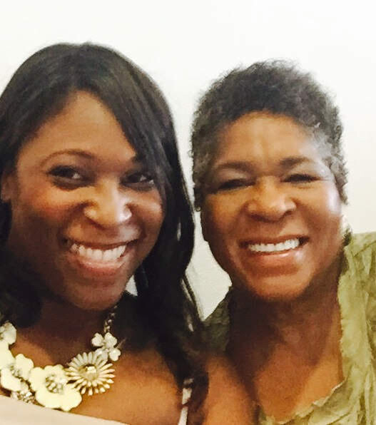 Two women smiling at the camera, posing closely for a selfie.