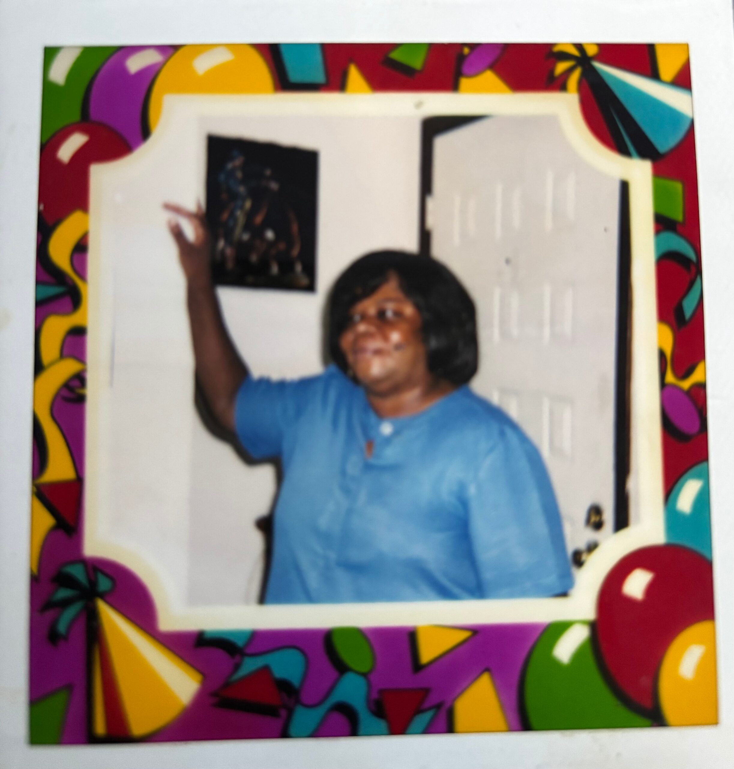 Portrait of a person in a blue shirt raising an arm, inside a bright, colorful party-frame border with balloons and shapes.