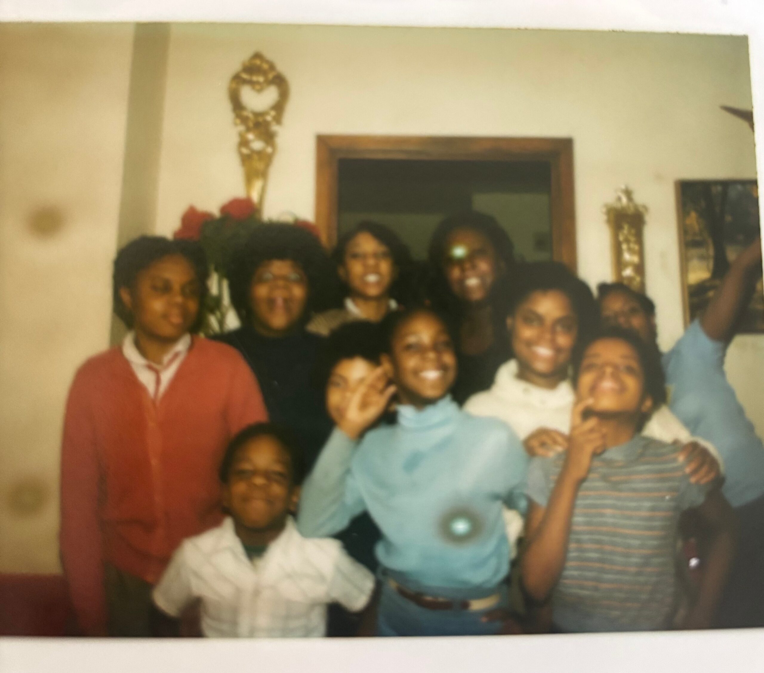 Group of people posing together for a family photo in a living room, everyone smiling at the camera.