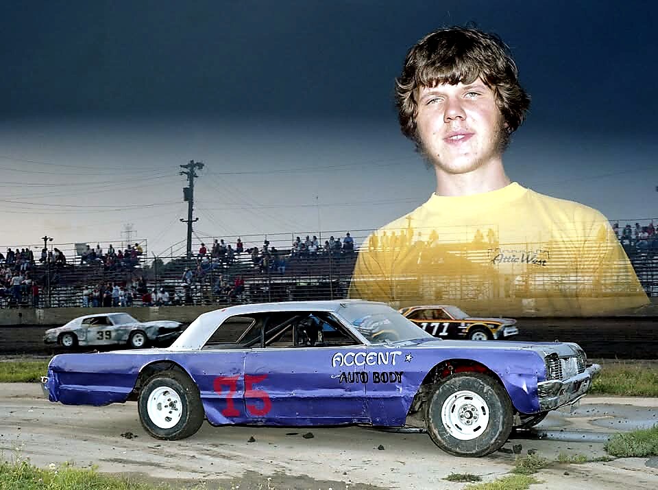 Blue vintage race car with red number 15 on a dirt track, crowd watching from the stands, and a large translucent portrait of a young man in a yellow shirt above the scene.