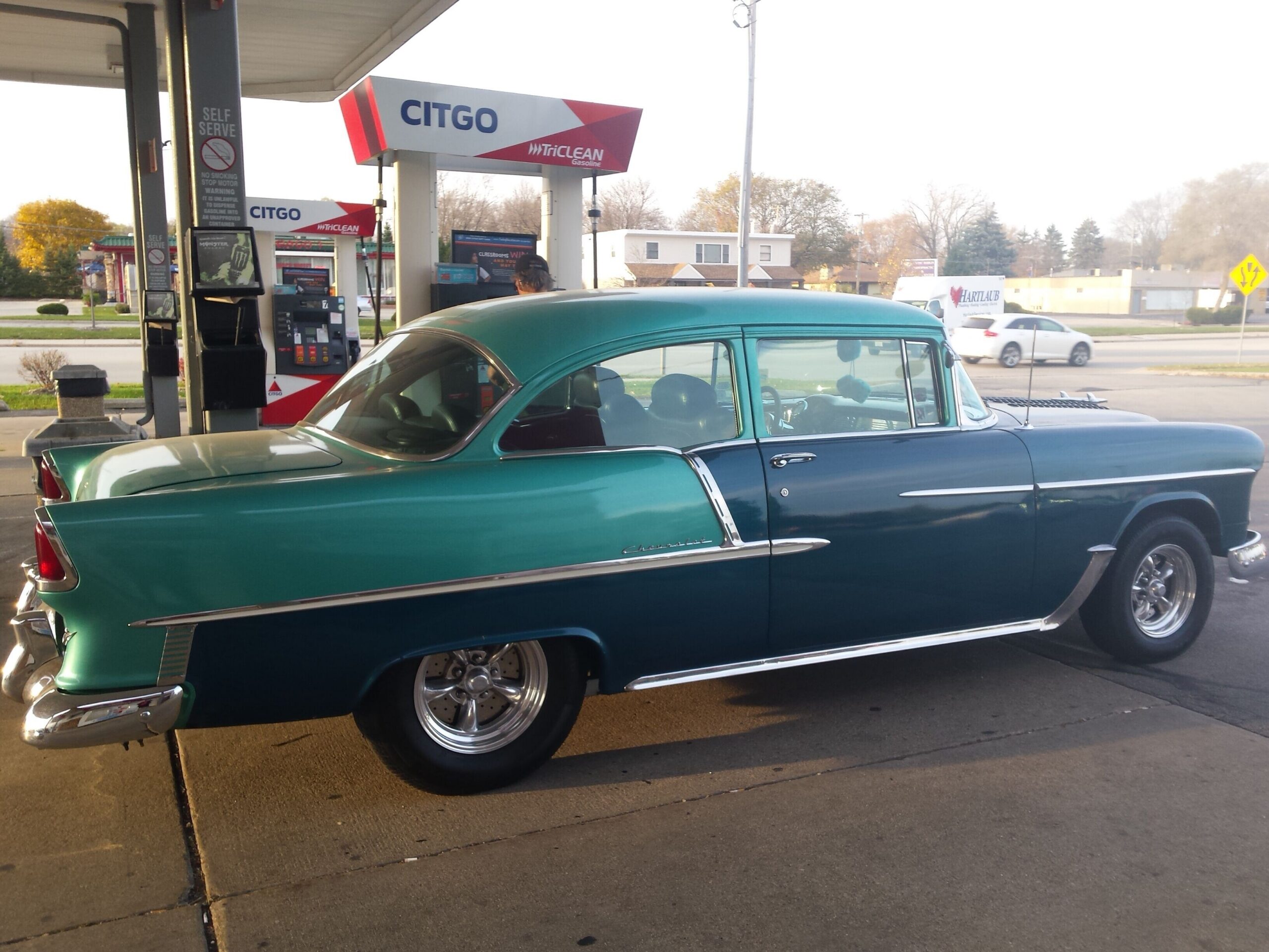 Teal vintage car with chrome trim at a Citgo gas station, pumps visible in the background.