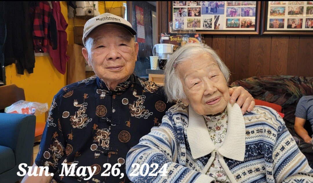 Two elderly people sit close together in a cozy cafe, smiling warmly; overlay text reads Sun. May 26, 2024.