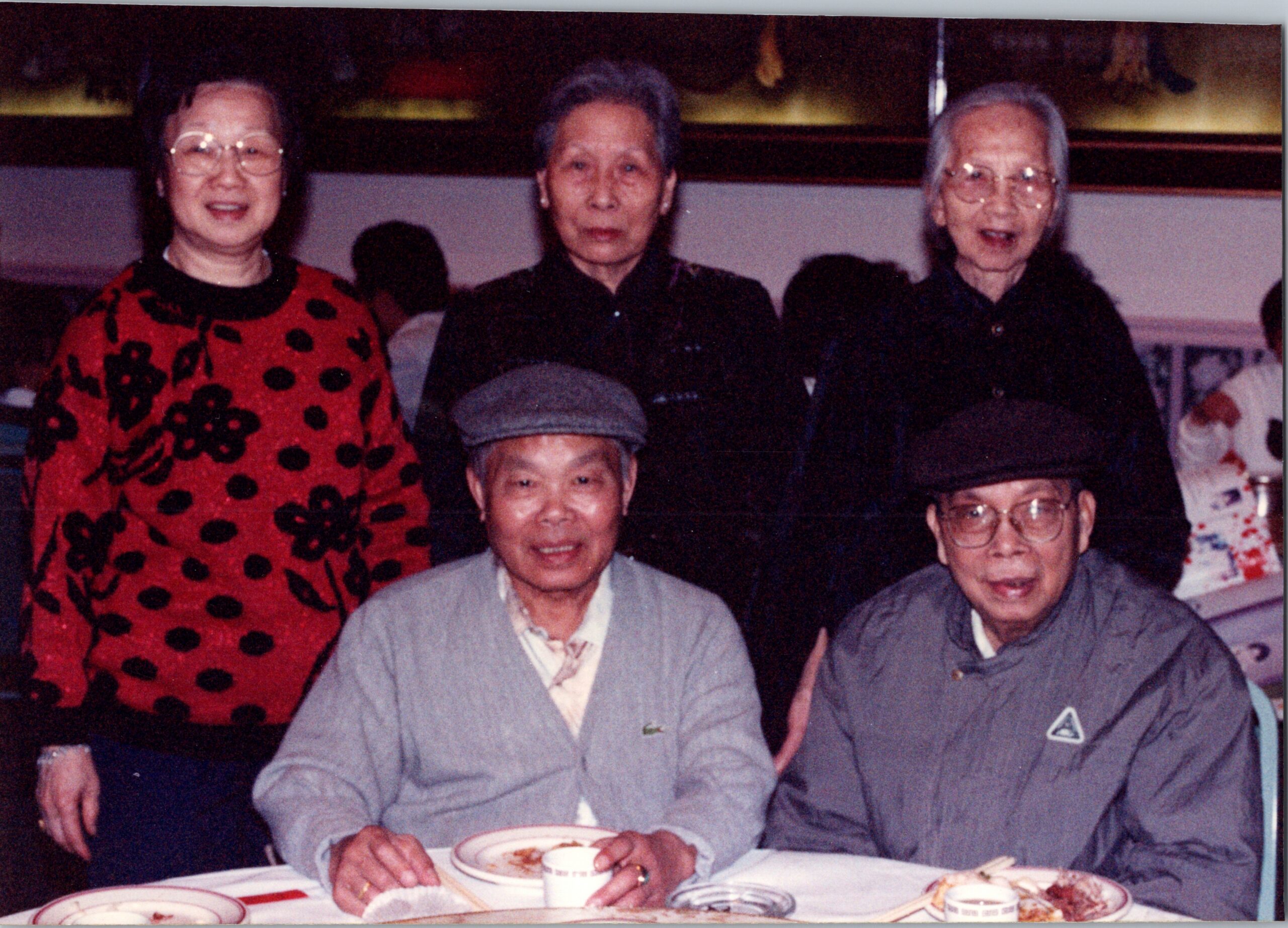 Group of five seniors posing for a photo at a dinner table, with plates and cups in front of them.