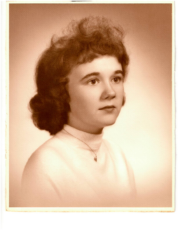 Vintage portrait of a young woman with short, wavy dark hair, wearing a light sweater and a small pendant necklace, looking slightly to the right.