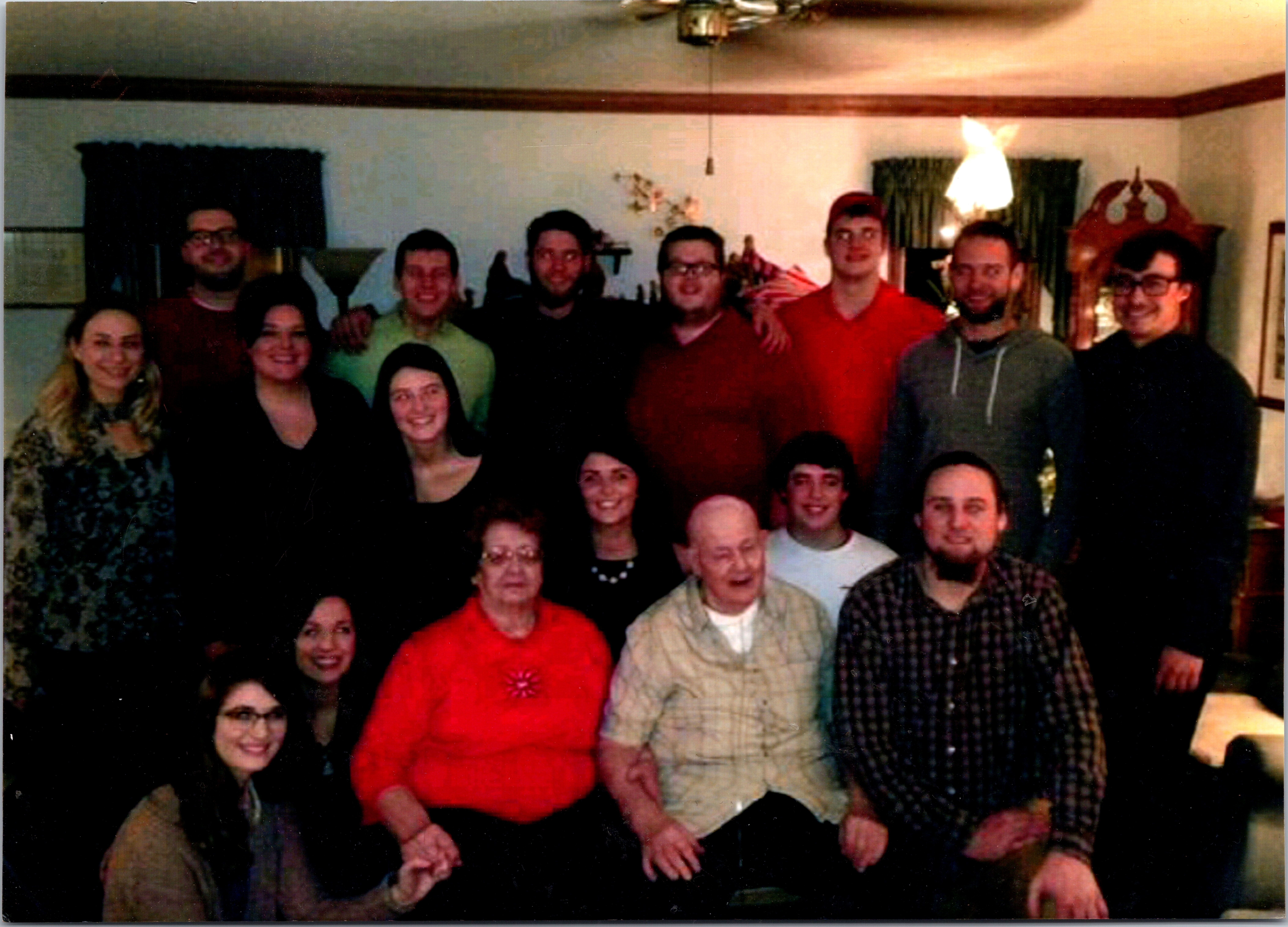 Group of adults and children posing together in a living room for a casual photo inside a home.
